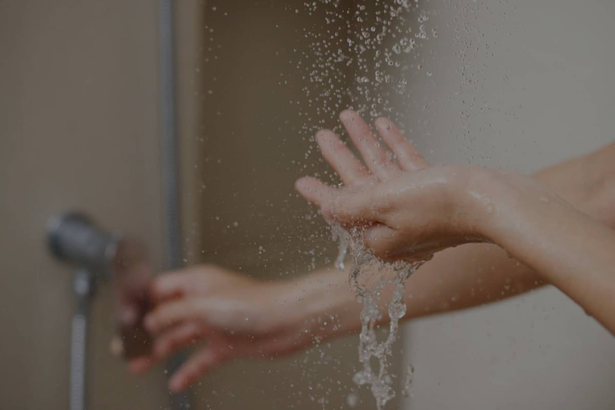 Hands feeling soft water in shower